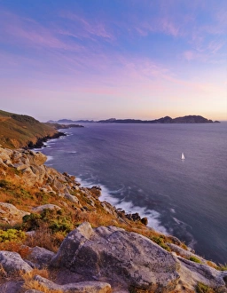 Spain, Galicia, Cangas, Yacht sailing in sea at dusk