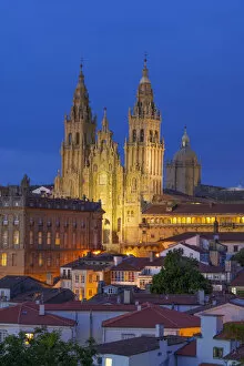 Spain, Galicia, Santiago de Compostela, view over rooftops to cathedral illuminated