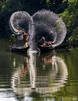 Spray Prints: Spray of backlit water created as local fishermen clean their nets