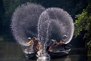 Spray Prints: Spray of backlit water created as local fishermen clean their nets