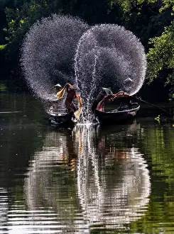 Spray Prints: Spray of backlit water created as local fishermen clean their nets