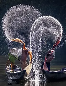 Spray Prints: Spray of backlit water created as local fishermen clean their nets