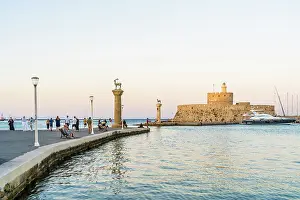 Rhodes Prints: The statues of the Myth Colossus of Rhodes at the Mandraki Marina and Port looking towards Saint Nicholas Fortress