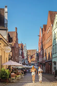 Alley Prints: Stintmarkt in the old town with street restaurants, Luneburg, Lower Saxony, Germany