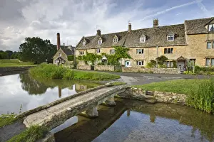 Stone footbridge and cottages at Lower Slaughter in the Cotswolds, Gloucestershire