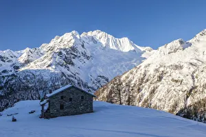 Stone hut at the foot of the snowy Monte Vazzeda, Alpe dell Oro, Valmalenco
