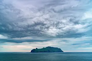 Cloudscape Prints: Storm clouds over Mykines island in the middle of the blue Atlantic ocean at dusk