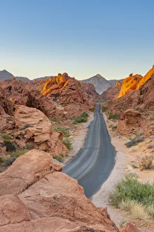 Straight road between red rocks at sunrise, Valley of Fire State Park, Nevada Straight road between red rocks at sunrise, Valley of Fire State Park, Nevada