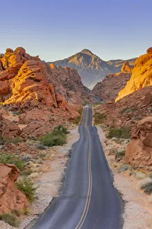 Straight road between red rocks at sunrise, Valley of Fire State Park, Nevada
