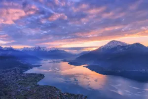 Stunning sunrise over the village of Dongo and Como Lake, from above. San Bernardo Church