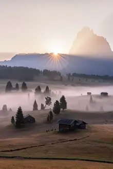 Barn Prints: Sun rays at dawn over the silhouette of Sassolungo and Seiser Alm in autumn fog