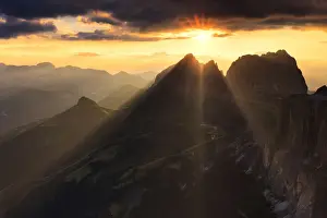 Passo Pordoi Prints: Sun rays filters between stormy clouds during sunset with Sassolungo group in