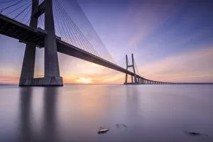 Images Dated 23rd February 2016: The sun rises on the Vasco da Gama Bridge that spans the Tagus River in Parque das NaA'A§A'Aµes