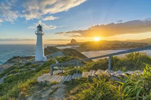 Images Dated 30th August 2018: The sun is setting down behind Castle Rock and Castlepoint lighthouse. Castlepoint