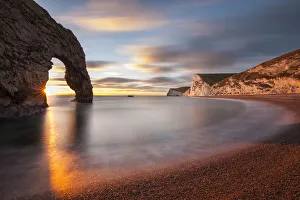 Natural Arch Prints: Sun setting through Durdle Door, Jurassic Coast, Dorset, England, UK