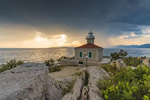 The sun is setting down behind St Peter lighthouse, in summer