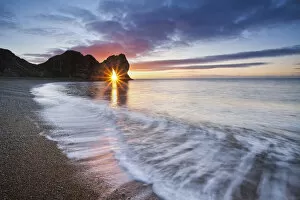 Coast Gallery: Sun shining through Durdle Door at sunrise, Jurassic Coast, Dorset, England, UK