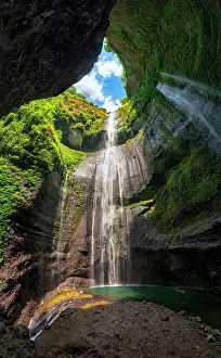Cave Prints: Sunlight breaks through the canyon as Madakaripura Waterfall tumbles into the green pool below