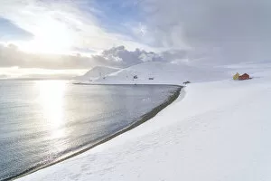 Snowfall Collection: Sunlight reflected in the cold sea surrounded by snow, Skarsvag, Nordkapp