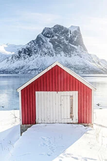 Fjord Collection: Sunlight over snowy mountains and fisherman cabin overlooking the arctic sea, Bergsfjord, Senja