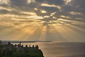 Images Dated 20th September 2021: Sunrays over Dunluce Castle at Sunset, County Antrim, Northern Ireland