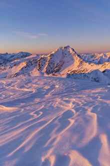 Sunrise light to Gavia pass mountains from a snowcapped summit during winter