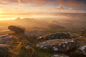 Sunrise over a misty moor viewed from Littaford Tor, Dartmoor, Devon, England. Autumn