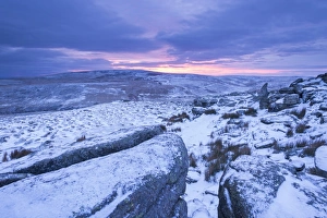 Sunrise above a snow covered moorland, Belstone Tor, Dartmoor National Park, Devon, England Sunrise above a snow covered moorland, Belstone Tor, Dartmoor National Park, Devon, England