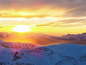 Cloudscape Prints: Sunrise over snowcapped mountains along a frozen fjord