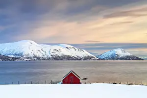 Cloudscape Prints: Sunrise over snowcapped mountains and a red fisherman cabin along the fjord