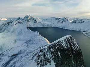 Mountain Ridge Prints: Sunrise over the snowcapped Segla mountain overlooking a fjord