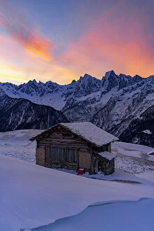 Climate Collection: Sunrise over snowy mountains view from lone alpine chalet, Tombal, Soglio, Val Bregaglia