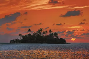 Sunrise in the tropics with palm island - Maldives, South Male Atoll