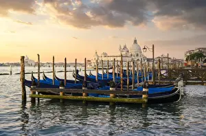 Sunrise in Venice with gondolas and Santa Maria della Salute church on the background
