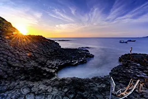 Basalt Prints: Sunrise over the volcanic rock formations of Ghenh Da Dia bassalt rocks, Phu Yen, Vietnam