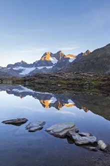 Sunrisescape at Confinale pass alpine lake during summer