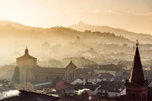 Emilia Prints: Sunset in Bologna, rooftops and hills in background with Santuario di San Luca