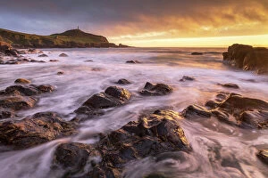 Sunset over Cape Cornwall from the rocky shores of Porth Ledden, Cornwall, England. Spring (May) 2022