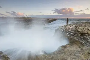 Sunset on the cliffs of Devils Bridge submerged by crashing waves Caribbean Antigua