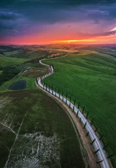 Crop Prints: Sunset over the winding road of the Podere Baccoleno in the Crete Senesi, Tuscany, Italy