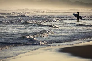 A surfer observes sea at Playa del Puntal, Santander, Cantabria, Spain