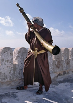 Islamic Dress Gallery: A Swahili man in traditional attire blows the Siwa
