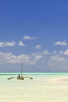 Images Dated 7th March 2012: Tanzania, Zanzibar, Unguja, Jambiani. A man sits on his boat
