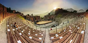 Dramatic Sky Prints: Taormina, Sicily. People sitting in the greek theater with the sun setting