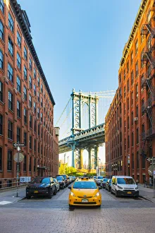 Taxi passing under the Manhattan bridge with the Empire state building framed in the Taxi passing under the Manhattan bridge with the Empire state building framed in the