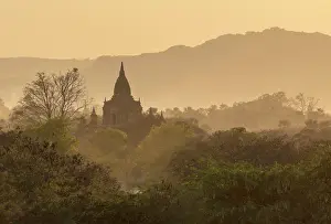 Mandalay Region Prints: Temple among trees and undergrowth at sunset