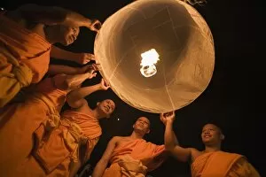 Thailand, Chiang Mai, San Sai. Monks launch a khom loi (sky lantern) during the Yi Peng festival