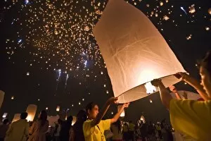 Thailand, Chiang Mai, San Sai. Revellers launch khom loi (sky lanterns) into the night sky during the Yi Peng festival