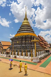 Shrine Collection: Thailand, Lampang, Wat Phrathat Lampang Luang, women walking infront of chedi