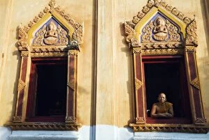 Thailand, Nong Khai, Nong Khai. A monk looks out from a window at Wat Hai Sok
